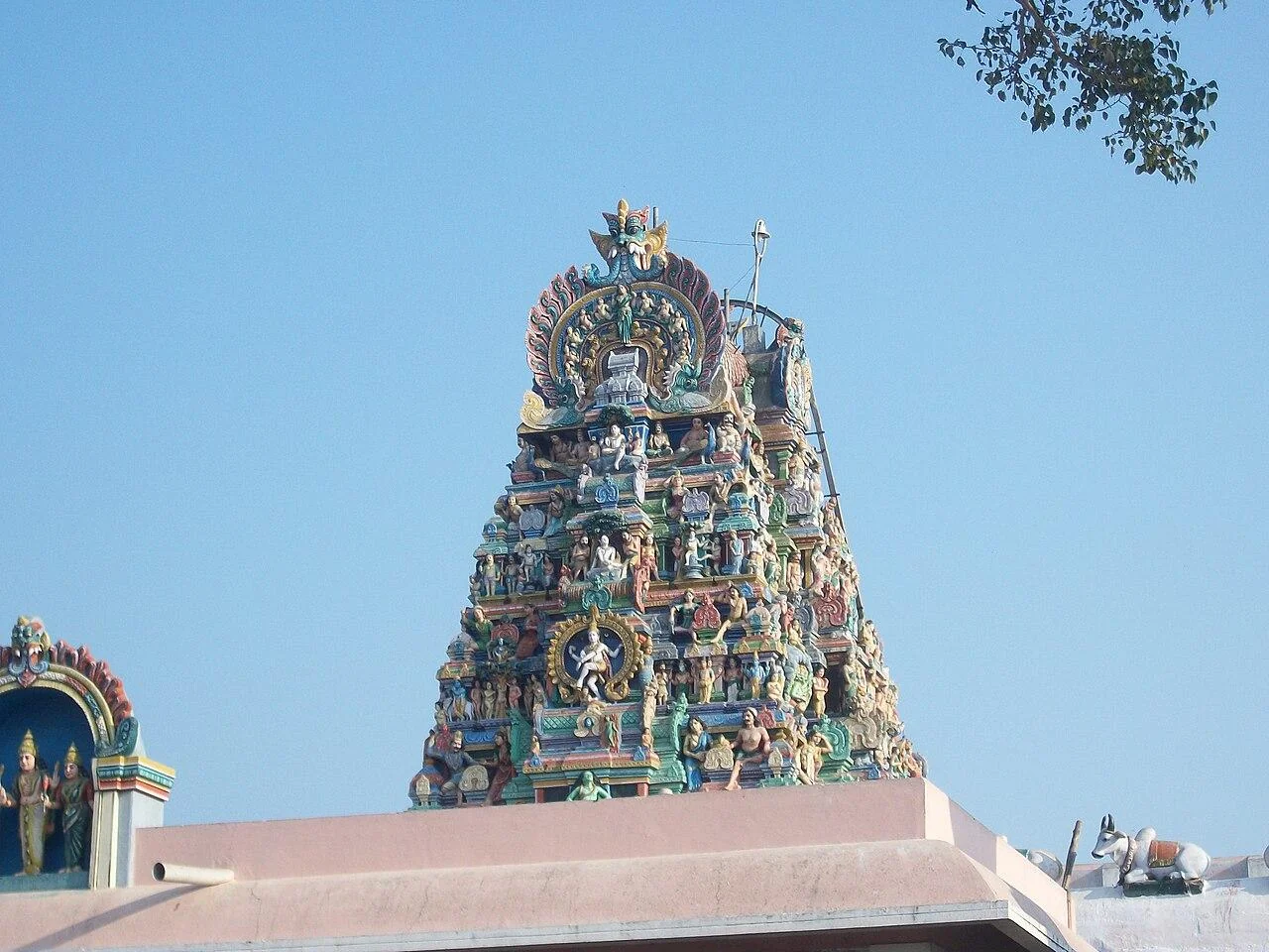 The carved gopuram of Dhandayuthapani Murugan Temple in Palani against a blue sky