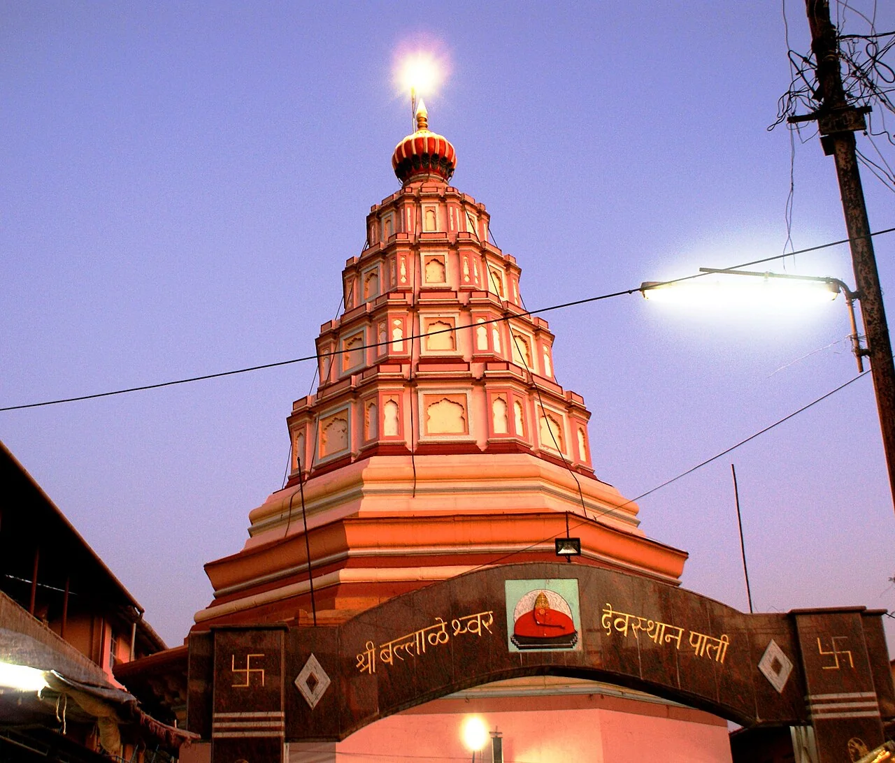 The orange entrance tower of Ballaleshwar Temple in Pali at dusk