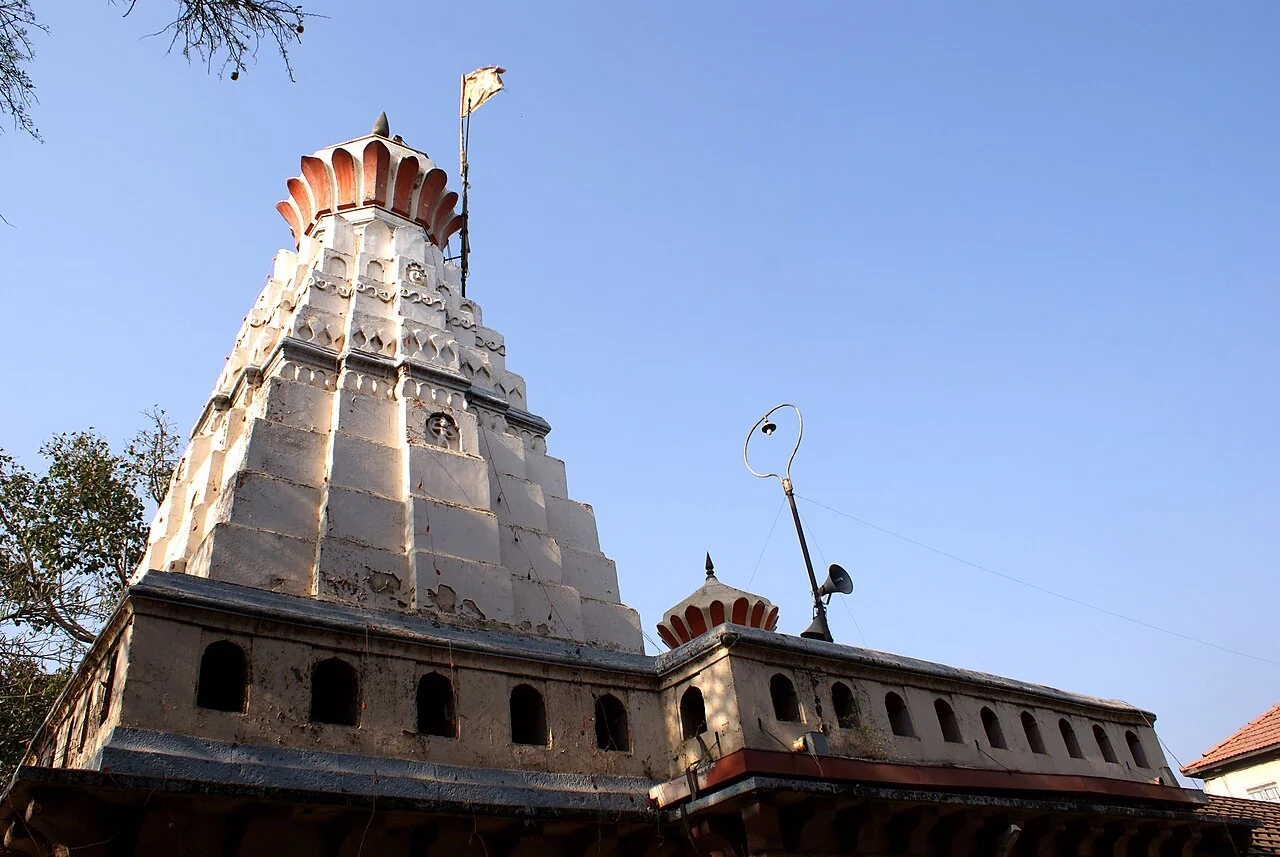 The stone entrance tower of Chintamani Temple in Theur against a blue sky