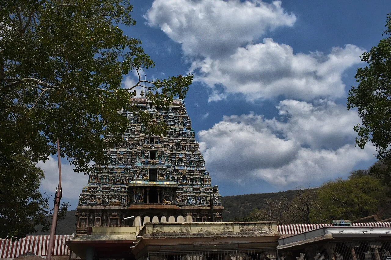 The carved entrance tower of Thiruparankundram Murugan Temple beneath clouds